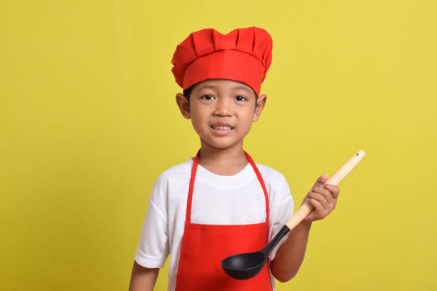 istock Cute little chef holding ladle. Asian boy cooking 2167554048