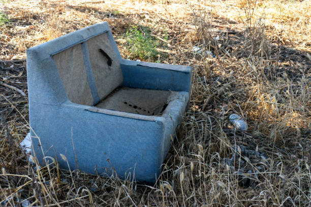 istock Plastic bottles and an old sofa discarded in a field 2167555126