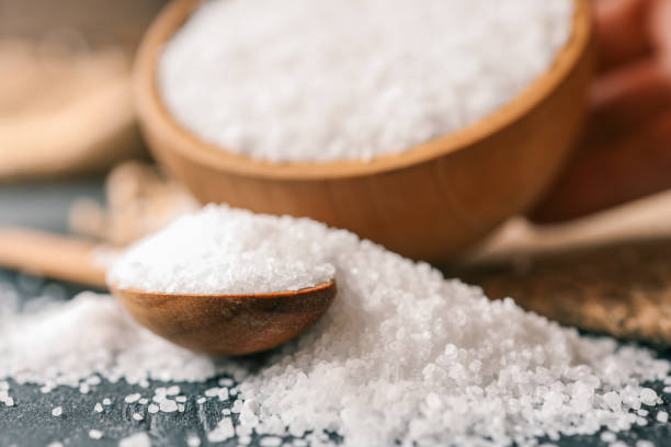istock Pour salt into a wooden spoon, close-up 2167557879