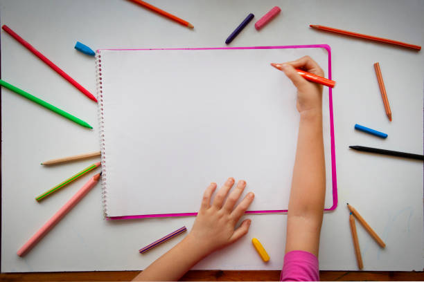 istock A child, an overhead view, and a blank page of work. 2167559673