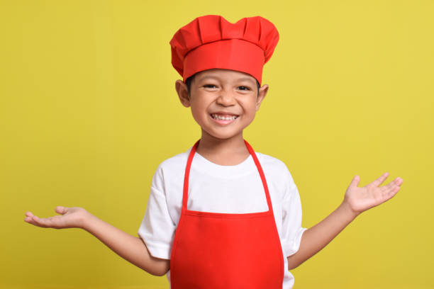 istock Asian boy wearing apron. Cute little chef with hand gesture aside 2167561902