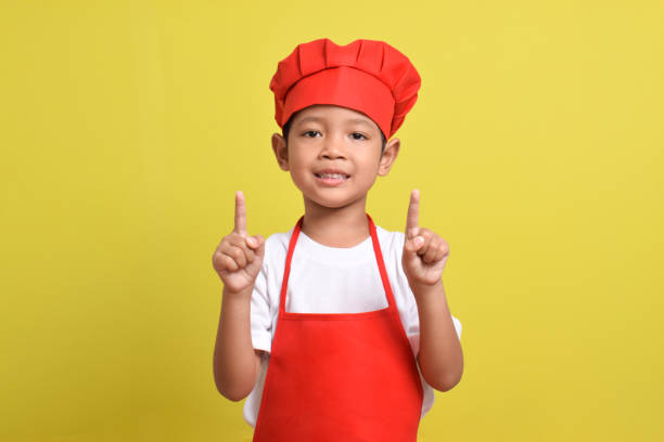 istock Cute little chef showing Blank Space above with hand gesture up 2167563221