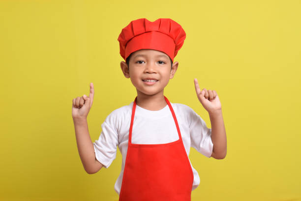 istock Cute little chef showing Blank Space above with hand gesture up 2167563386