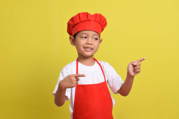 istock Cute little chef showing Blank Space Next to with pointing hand gesture 2167563456