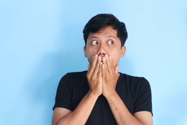 istock Shocked young Asian man with hand on his mouth 2167563466