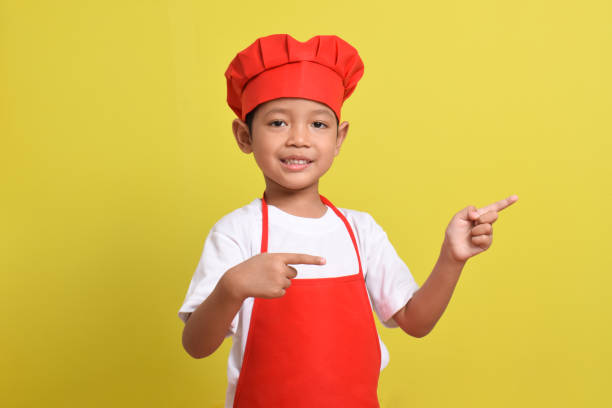 istock Cute little chef showing Blank Space Next to with pointing hand gesture 2167563550