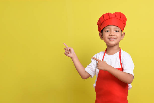 istock Cute little chef showing Blank Space Next to with pointing hand gesture 2167563729