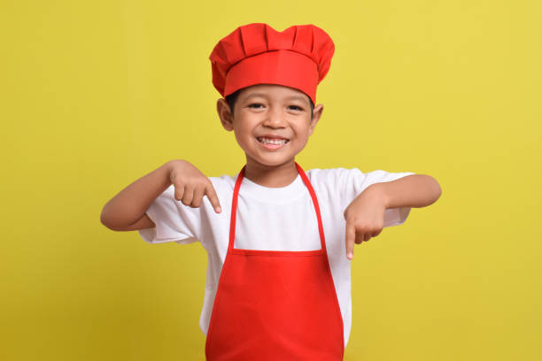 istock Cute little chef showing Blank Space down with hand gesture down 2167563799