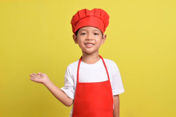 istock Cute little chef showing Blank Space Next to with pointing hand gesture 2167564024
