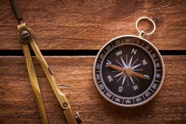 istock Vintage drawing and navigational Compass on a rustic wooden board 2167567820