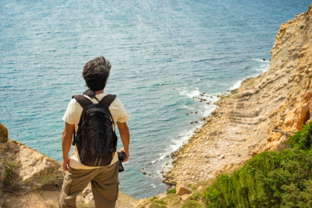 istock Back view of backpacker looking at the sea 2167568034
