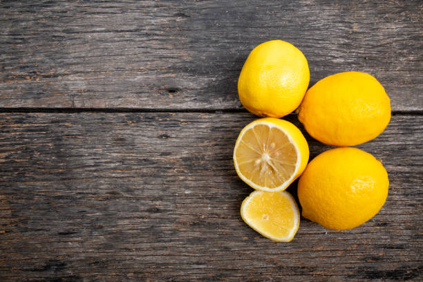 istock Fresh yellow lemons, healthy fruit on brown wooden table with copy space. 2167568418