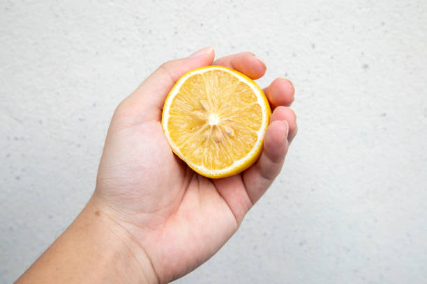 istock Hand holding a lemon on a white background 2167568476