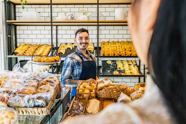 istock Young retail clerk serving customer at bakery 2167569811