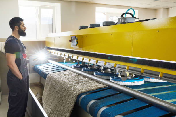 istock Man operating carpet automatic washing machine in professional laundry service 2167570500