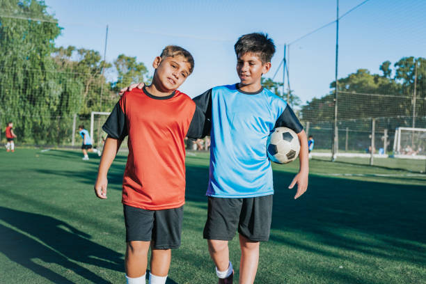istock two boys from opponent teams walking embraced  after match 2167573396