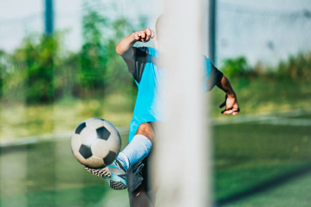 istock kicking the ball 2167573493