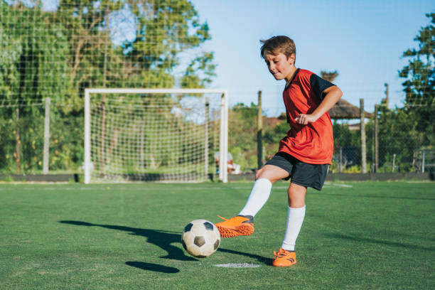 istock soccer boy kicking the ball on field 2167573703