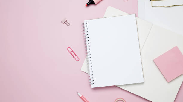 istock Creative flat lay mockup design of workspace. Top view composition with white notebook, to do list and stationery on pink background 2167574200