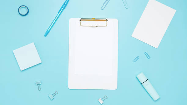 istock Creative flat lay mockup design of workspace. Top view composition with white notebook, to do list and stationery on blue background 2167574205