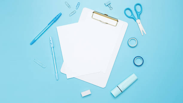 istock Creative flat lay mockup design of workspace. Top view composition with white notebook, to do list and stationery on blue background 2167574209