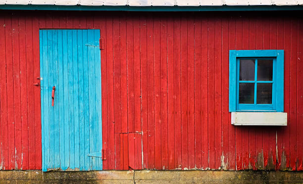 istock Rustic old red barn wood wall with cool blue barn wood door and small window background 2167577247