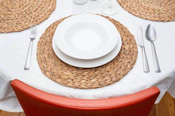 istock Elegant Table Setting with White Plates and Woven Placemats 2167578602
