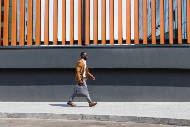 istock Confident businessman walking outdoors on a sunny day in urban setting 2167583864