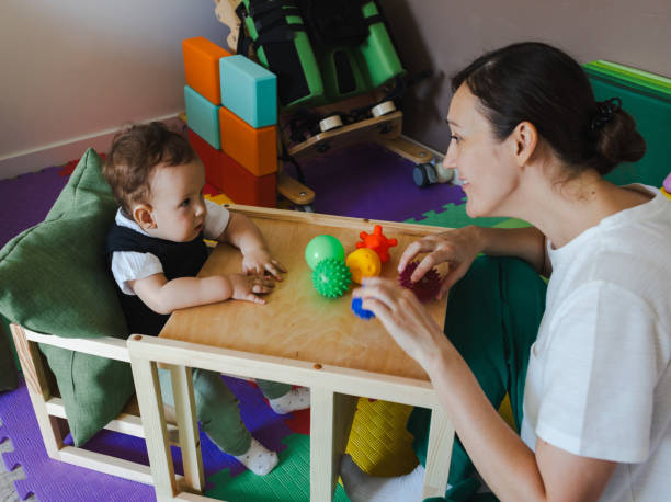 Occupational therapist performing a session of sensory integration therapy for a child during rehabilitation and treatment of male child in a rehab center. SIT in paediatric rehabilitation