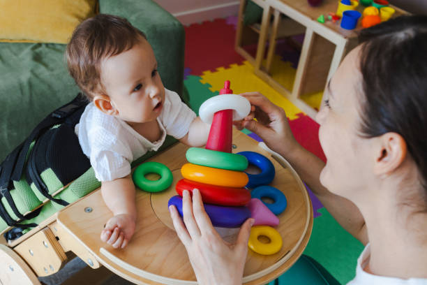 istock Mother spending useful time with her son with movement disorders playing developmental games while he stands in the rehabilitation verticalizer at home 2167584828