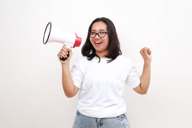 istock Announcement. Happy asian woman shouting loud at megaphone, recruiting, protesting with speaker in hands, standing over white background 2167584884