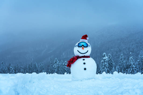 Funny snowman in ski glass in snowy mountains. Ski resort concept. Merry Christmass and happy New Year