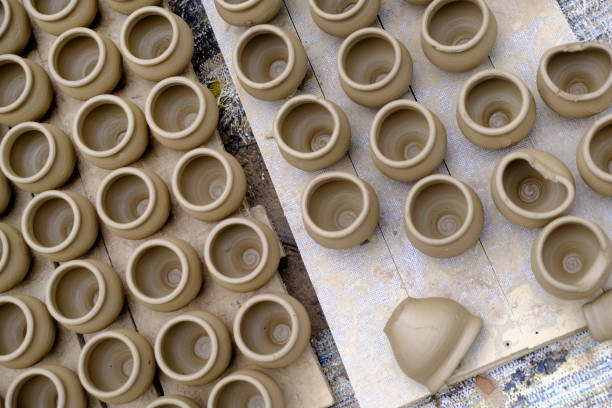 Skilled potter shaping the clay into pot on spinning wheel, Indian earthenware.