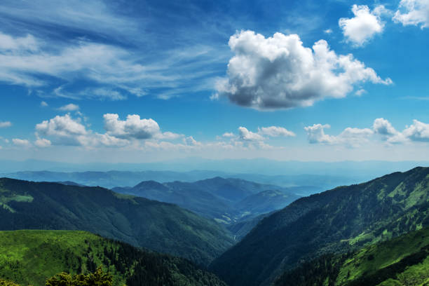 Beauty blue foggy mountains range. Cloudy sky and dark mountain peaks with glowing mist. Landscape photography