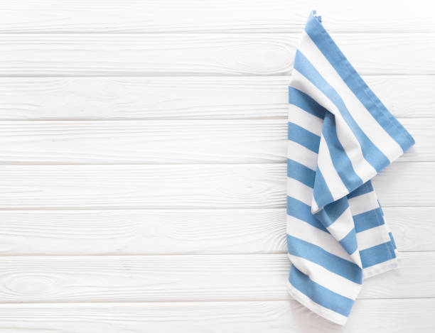 istock Blue kitchen towel crumpled top view on white wooden backgroud. Empty space food advertisement backdrop. 2167596175