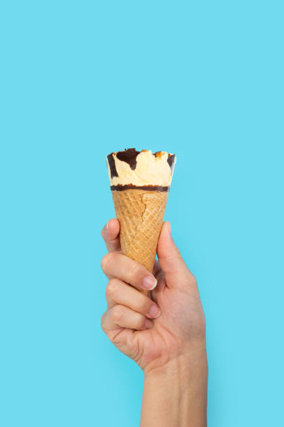 istock Hand holding ice cream cone on blue background 2167600506