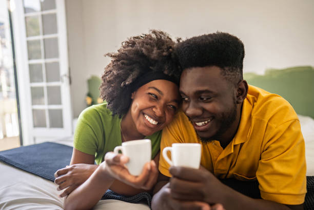 istock Couple lying down in bed while drinking coffee in a hotel room 2167604985