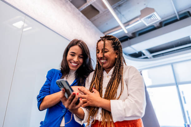 istock Coworkers talking and using mobile phone at office 2167605423