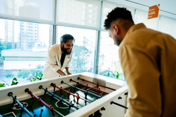 istock Young coworkers playing foosball at office 2167606088