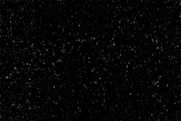 istock Snowflakes falling gently against a stark black background during a winter evening in a tranquil setting. 2167607589