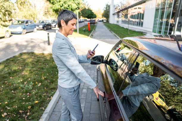 istock Businesswoman using phone while getting into the car 2167607801