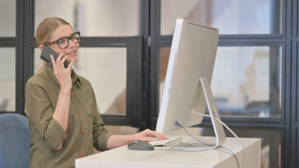 istock Young Businesswoman Working on Desktop and Using Smartphone 2167608431