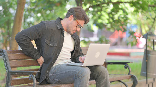 istock Middle Aged Man Using Laptop Outdoor and Feeling uncomfortable with Back Pain 2167613198