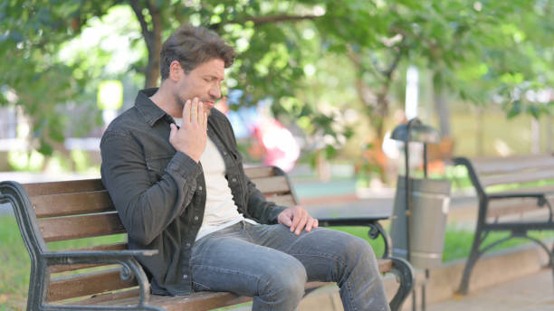 istock Middle Aged Man with Toothache Sitting Outdoor 2167615921