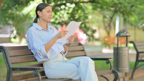 istock Mixed Race Woman Shocked while Reading Documents Outdoor 2167616434