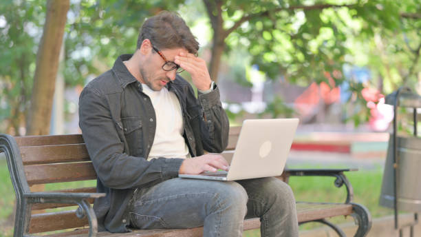 istock Middle Aged Man with Migraine Using Laptop Outdoor 2167617229