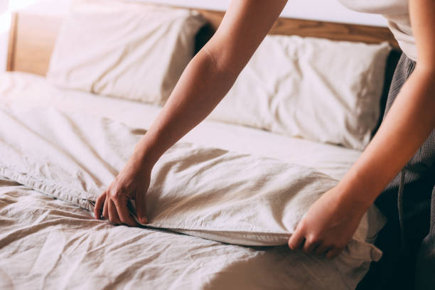 istock Person Making Bed with Fresh White Sheets at Home 2167617423