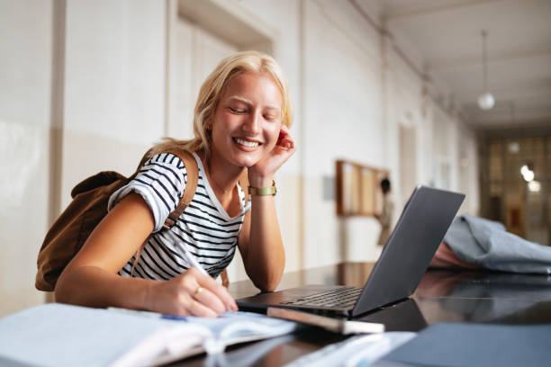 istock Happy University Student Studying in Library with Laptop 2167617549