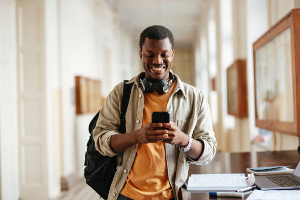 istock Happy University Student Texting on Smartphone in Campus Hallway 2167617594