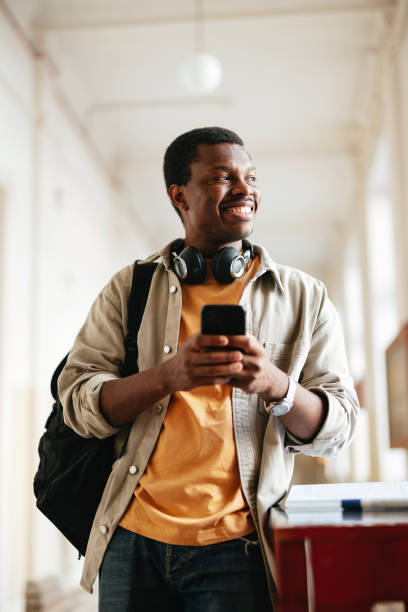 istock Happy University Student Holding Phone in Campus Hallway 2167617601
